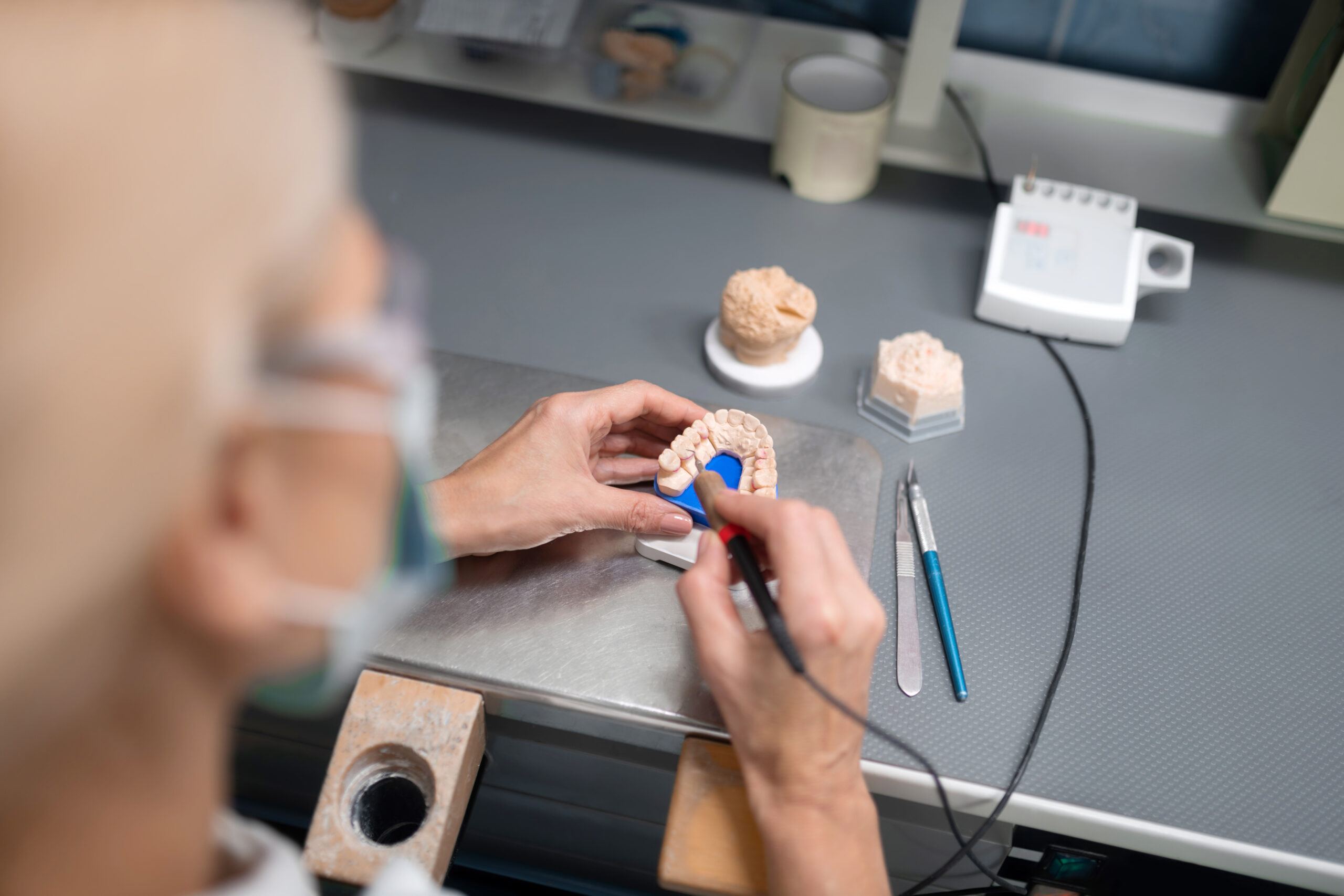 Making new teeth. Process of making porcelain veneers in office of dental technician in dental clinic.